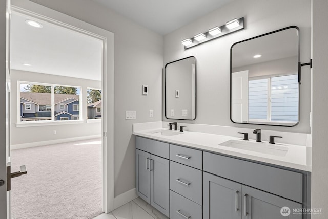 full bathroom featuring a sink, baseboards, double vanity, and recessed lighting