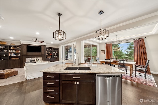 kitchen with stainless steel dishwasher, pendant lighting, sink, and a kitchen island with sink