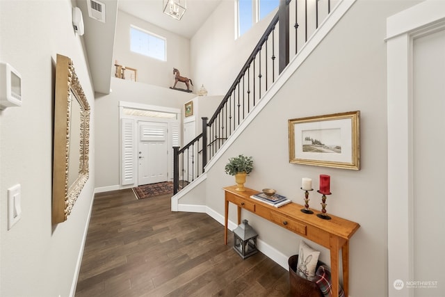 foyer with dark hardwood / wood-style flooring and a towering ceiling