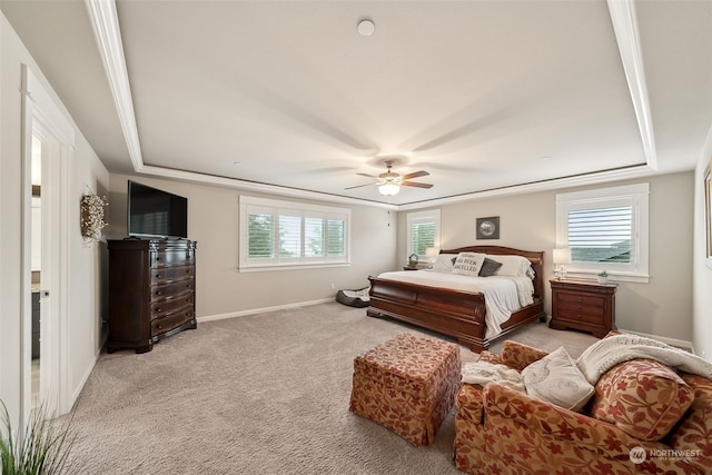 carpeted bedroom featuring ceiling fan and a tray ceiling