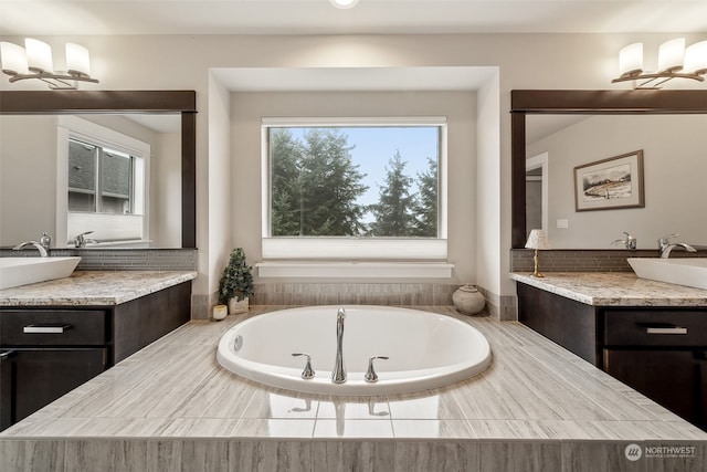 bathroom with a washtub and vanity