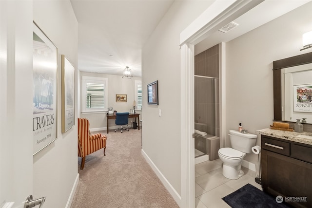 bathroom with vanity, toilet, and a shower with door