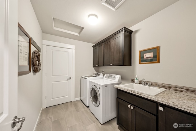 laundry room featuring cabinets, separate washer and dryer, and sink