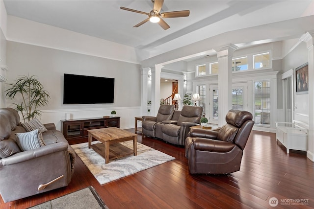 living room featuring dark wood-type flooring, decorative columns, stairway, and a ceiling fan