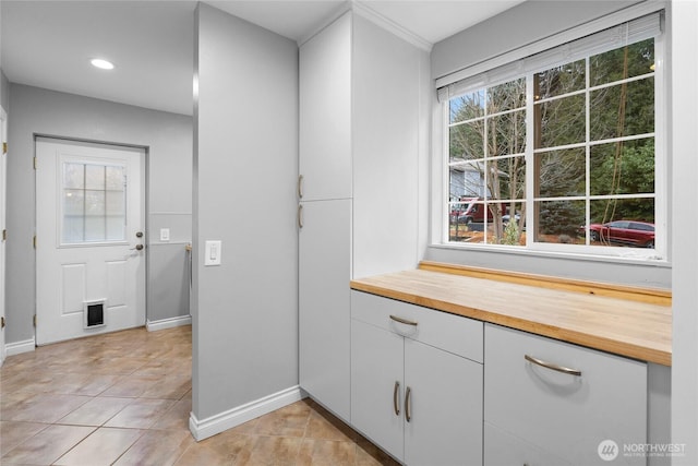 interior space with plenty of natural light, baseboards, and tile patterned floors