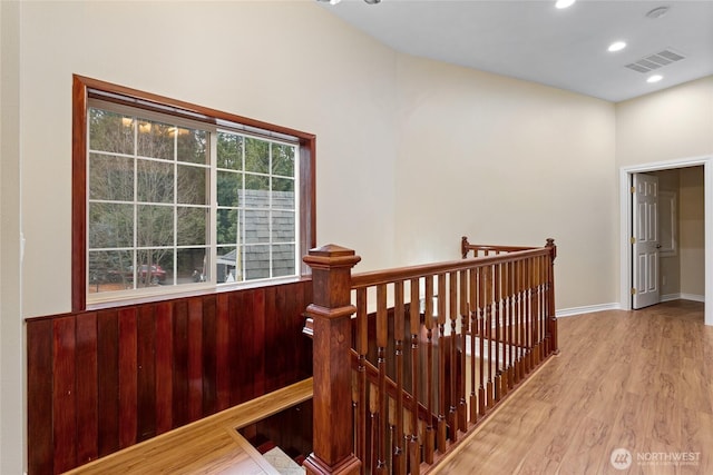 corridor with baseboards, visible vents, wood finished floors, an upstairs landing, and recessed lighting