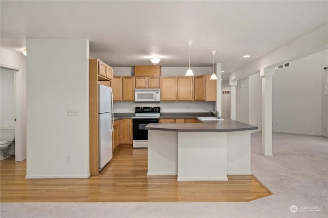 kitchen with kitchen peninsula, white appliances, light colored carpet, sink, and pendant lighting