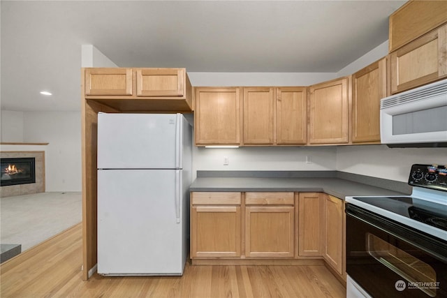 kitchen featuring light hardwood / wood-style floors, white appliances, a fireplace, and light brown cabinetry