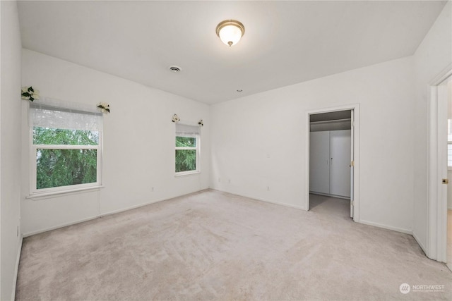 unfurnished bedroom with a closet and light colored carpet