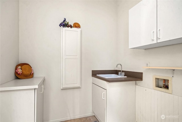 clothes washing area with cabinets, sink, and hookup for a washing machine