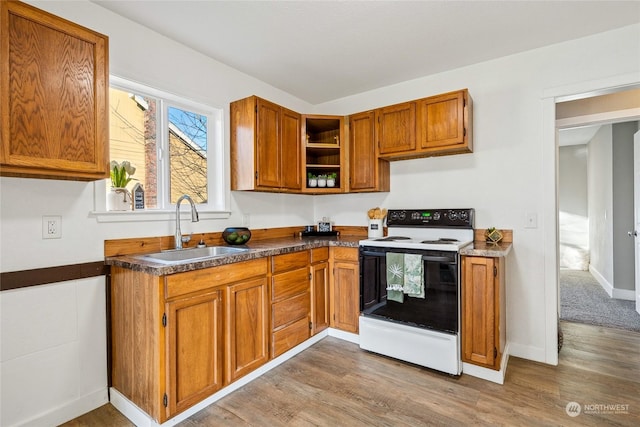 kitchen with electric stove, sink, and light hardwood / wood-style flooring