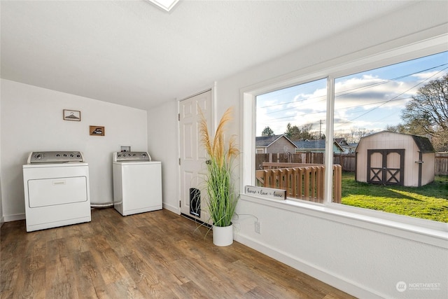 laundry room with washing machine and dryer and hardwood / wood-style floors