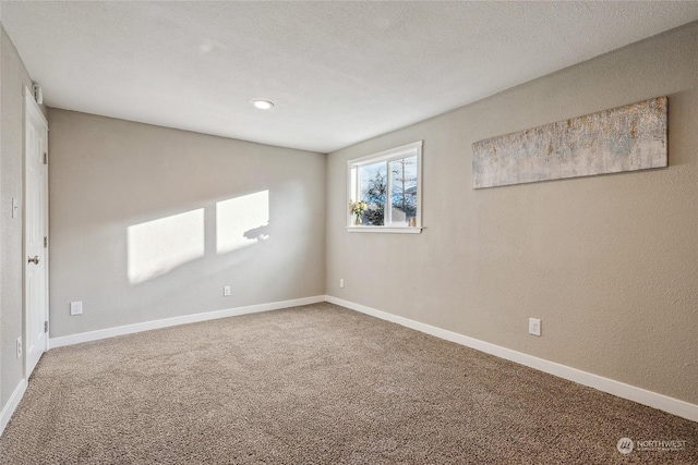 unfurnished room featuring carpet flooring and a textured ceiling