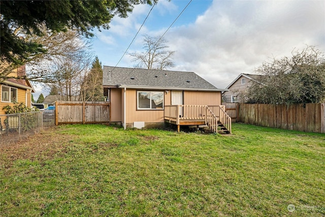 rear view of house with a deck and a yard