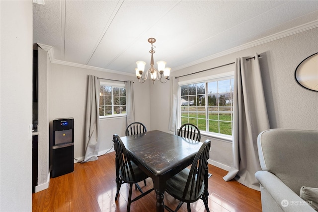 dining space with a chandelier, wood-type flooring, and ornamental molding