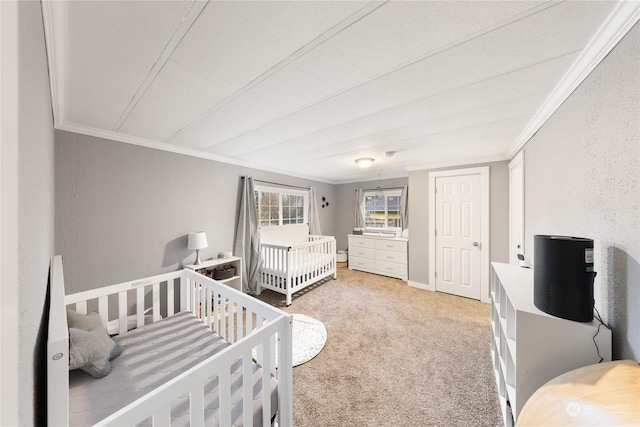 bedroom with carpet, crown molding, and a nursery area