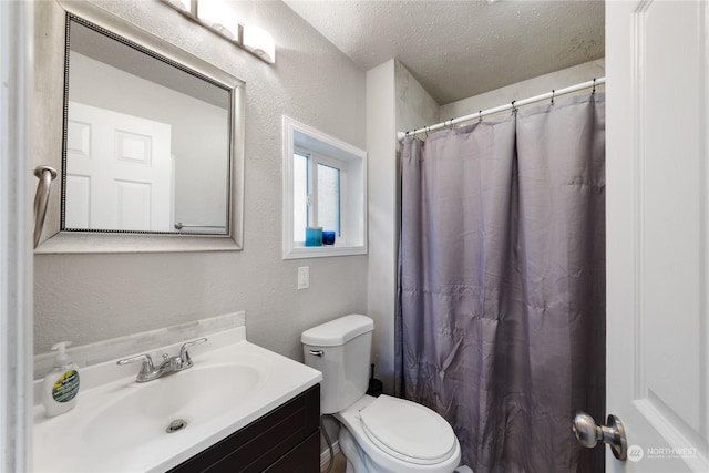 bathroom featuring vanity, a textured ceiling, and toilet