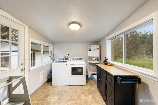 laundry room featuring plenty of natural light, a textured ceiling, and independent washer and dryer