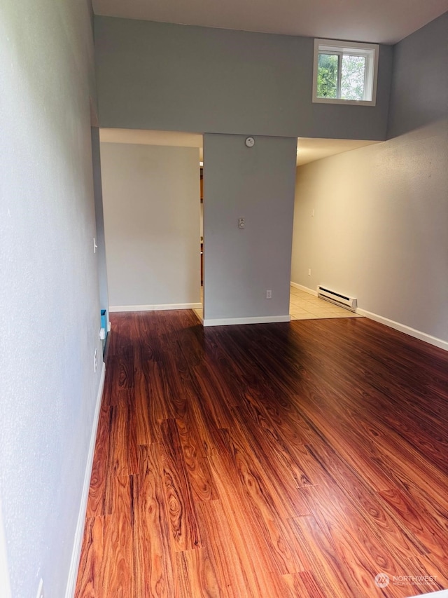 unfurnished room featuring a baseboard radiator and wood-type flooring