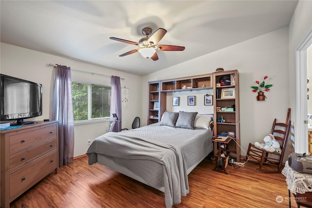 bedroom featuring light hardwood / wood-style floors, vaulted ceiling, and ceiling fan