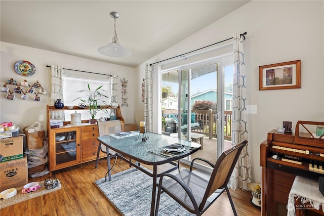 dining room featuring wood-type flooring and lofted ceiling