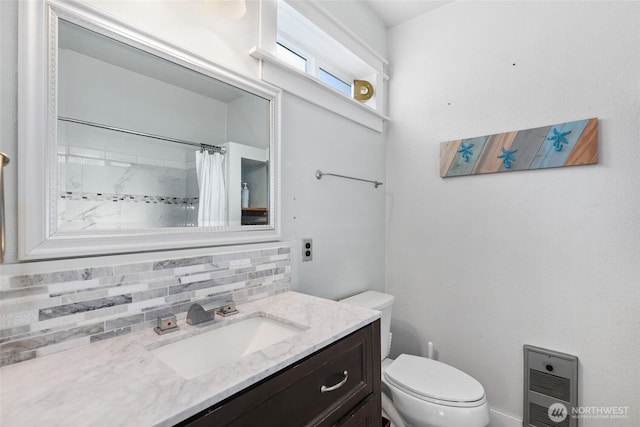 bathroom featuring heating unit, decorative backsplash, vanity, walk in shower, and toilet