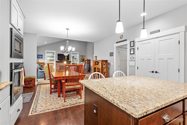 kitchen featuring stainless steel appliances, white cabinetry, and hanging light fixtures