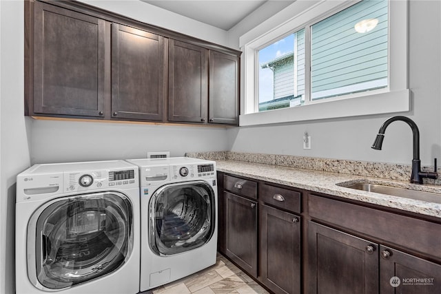 washroom featuring cabinets, washing machine and clothes dryer, and sink