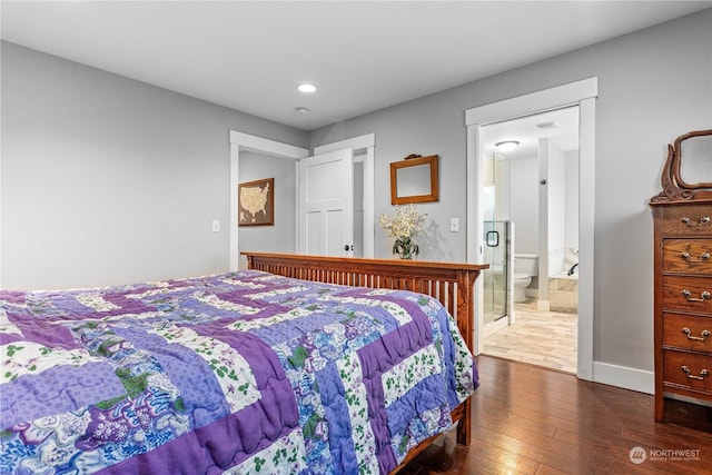 bedroom with ensuite bath and dark wood-type flooring