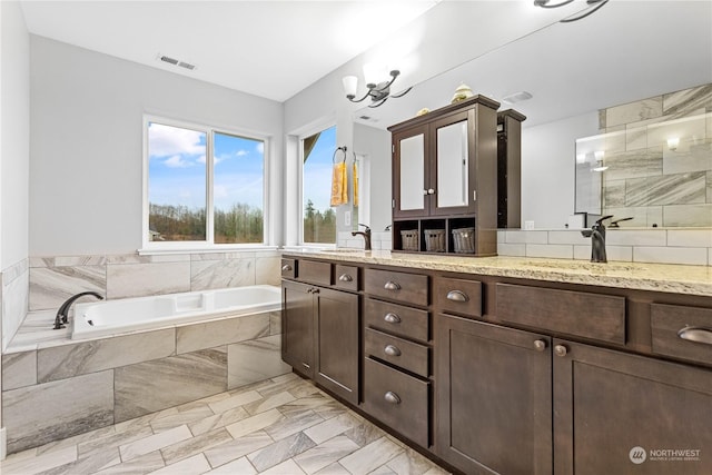 bathroom featuring plus walk in shower, vanity, and an inviting chandelier