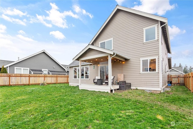 back of house featuring a lawn and a patio area