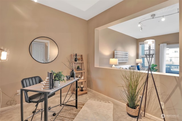 carpeted office space featuring rail lighting