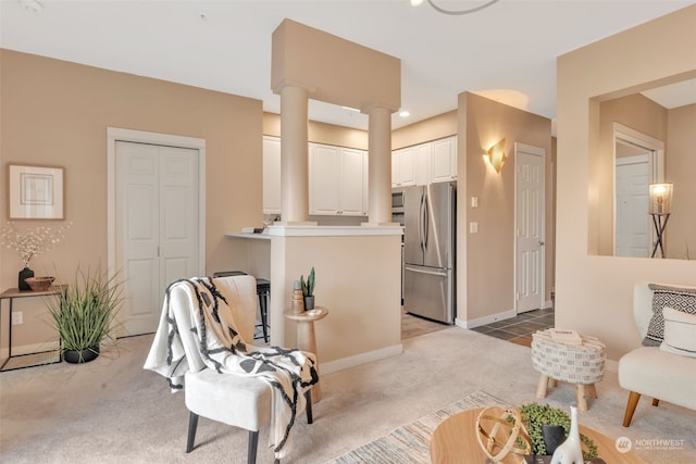 sitting room with light carpet and decorative columns