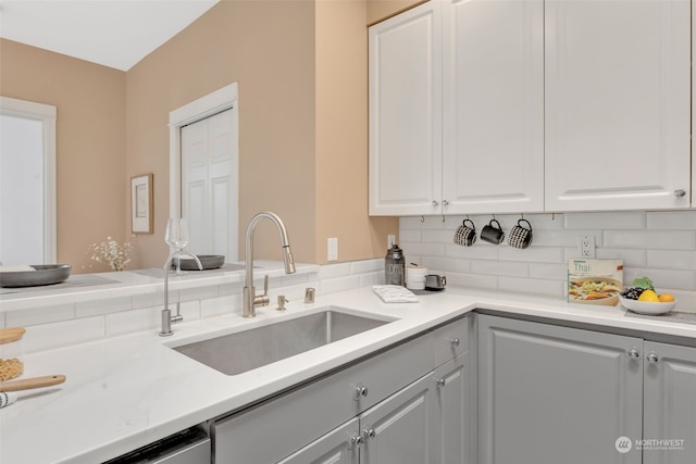 kitchen with white cabinets, backsplash, and sink