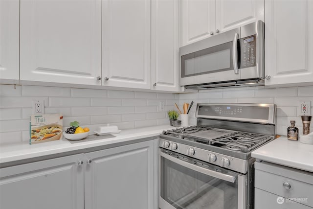 kitchen with white cabinets, appliances with stainless steel finishes, and tasteful backsplash