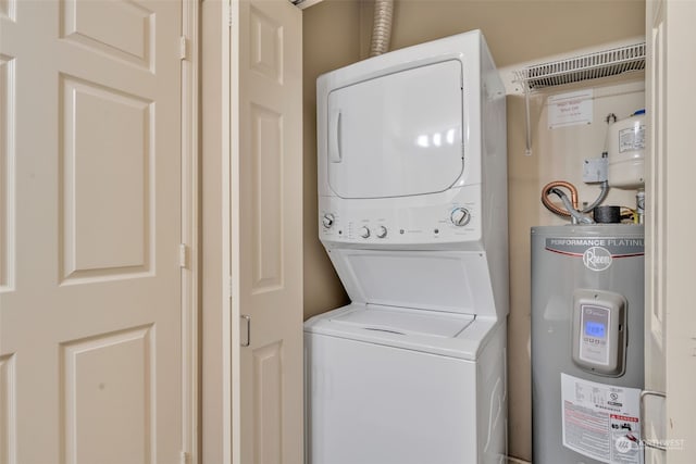 washroom with electric water heater and stacked washing maching and dryer