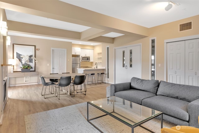 living room featuring light hardwood / wood-style floors and sink