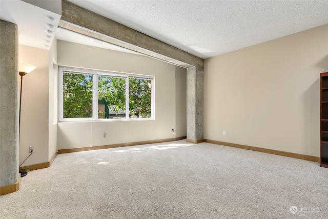 carpeted empty room with a textured ceiling