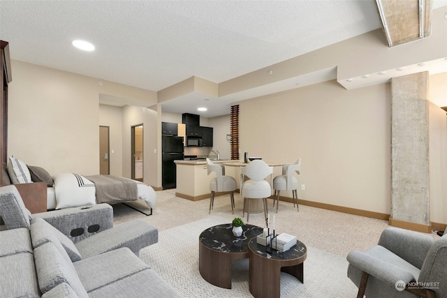 carpeted living room featuring sink and a textured ceiling