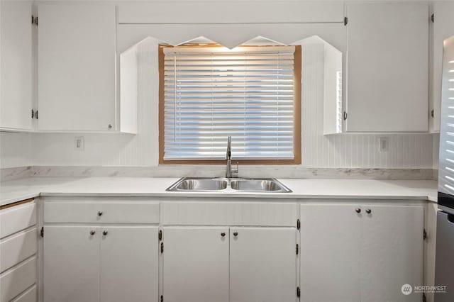 kitchen featuring sink and white cabinetry