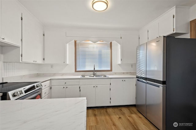 kitchen featuring sink, white cabinets, light wood-type flooring, and appliances with stainless steel finishes