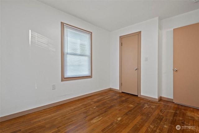 unfurnished room featuring dark wood-type flooring