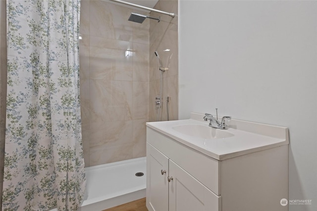 bathroom featuring a tile shower and vanity