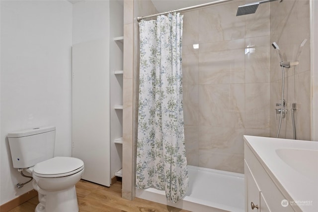 bathroom with hardwood / wood-style floors, toilet, vanity, and a shower with curtain