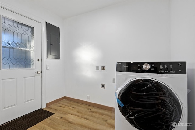 clothes washing area with electric panel, hardwood / wood-style flooring, and washer / dryer