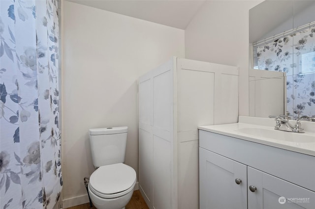 bathroom with vanity, toilet, and curtained shower