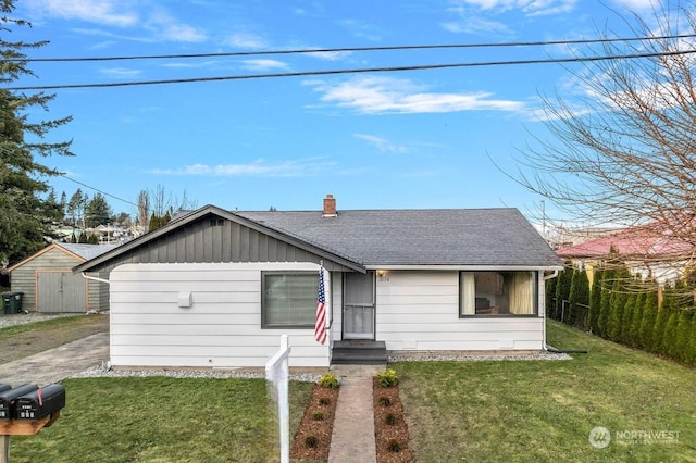 ranch-style home with a front yard and a shed