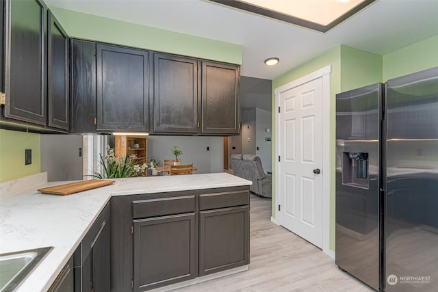 kitchen featuring fridge with ice dispenser, sink, and light hardwood / wood-style floors