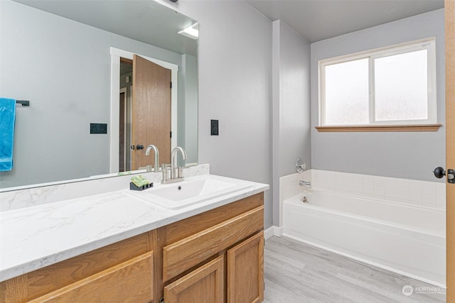 bathroom featuring vanity, a bath, and hardwood / wood-style flooring