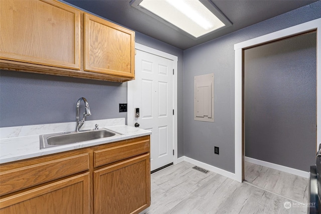 laundry room featuring light hardwood / wood-style flooring and sink